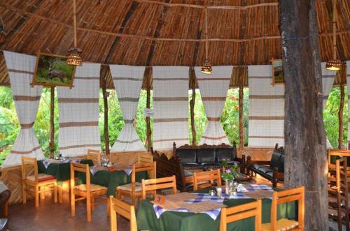 TurmiBusca Lodge的一间带桌椅和屋顶的餐厅