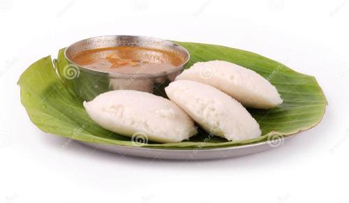Een bord met eten en een kopje thee op een bananenblad. bij Hotel Krishna Anandam in Vrindāvan