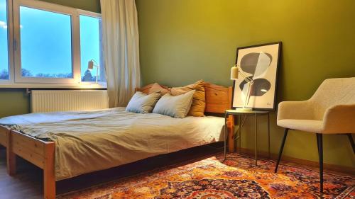 a bedroom with a bed with a chair and a window at PAE korter Kärdlas in Kärdla