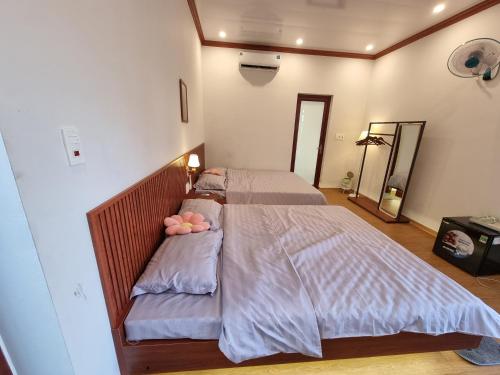 een slaapkamer met twee bedden met roze kussens bij BeanHomestay in Quang Ninh