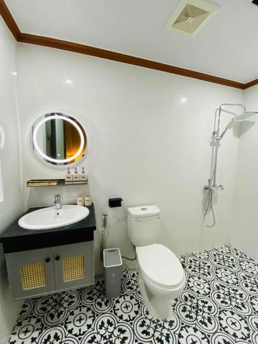 a bathroom with a toilet and a sink and a mirror at BeanHomestay in Quang Ninh