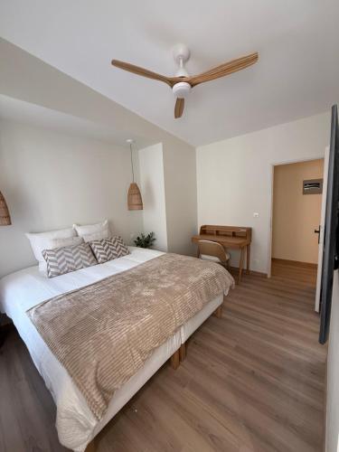 Maison Massilia Duclaux في مارسيليا: غرفة نوم بسرير كبير ومروحة سقف