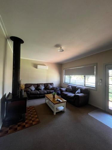 a living room with a couch and a fireplace at Spring Valley Cottage in Parkes
