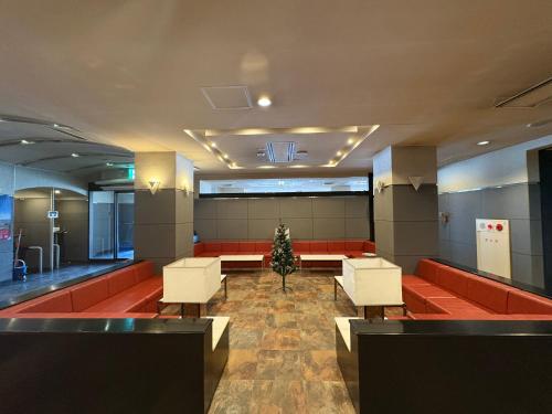 a waiting room with red couches and a christmas tree at 彦根びわこホテル無料駐車場ありペット同伴可 in Hikone