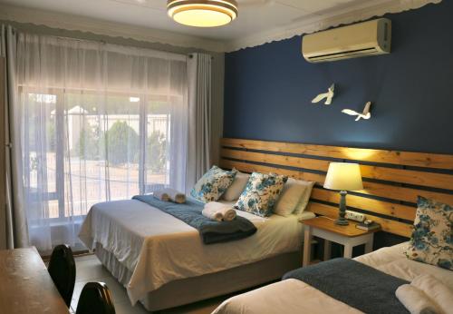 a bedroom with two beds and a window at Tuscany Vryburg in Vryburg