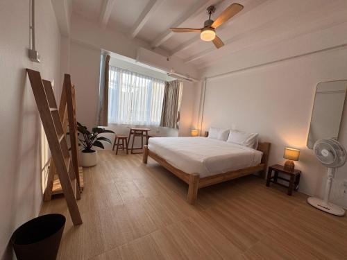 een slaapkamer met een bed en een tafel met een ventilator bij Cloud House in Chiang Mai