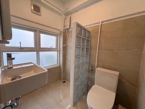 een badkamer met een wastafel en een toilet en een raam bij Cloud House in Chiang Mai