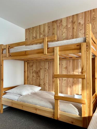 two bunk beds in a room with wooden walls at AgroDomek Rzepiska in Rzepiska