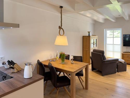 een keuken en woonkamer met een tafel en stoelen bij Haus Dünenperle, Ferienwohnung Wanderdüne in Wittdün