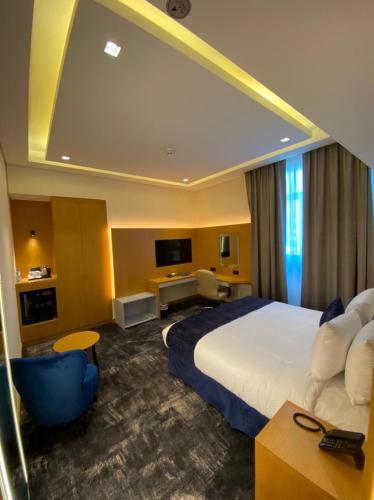 a hotel room with a large bed and a tv at AL HAYAT HOTEL in Sharjah