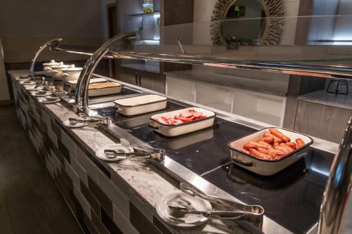 a kitchen with several dishes of food on a counter at Mercure Newcastle George Washington Hotel Golf & Spa in Newcastle upon Tyne