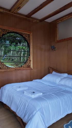 een slaapkamer met een groot wit bed met een raam bij O-Frame by WildFoot in Kabaru