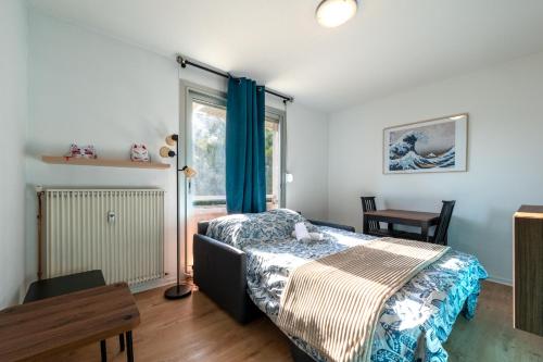 ein Schlafzimmer mit einem Bett und einem Fenster in der Unterkunft Kokoro - Parking in Ramonville-Saint-Agne