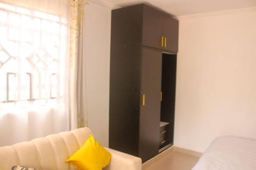 BungomaMiranda suites的房间里有一张沙发和一扇窗户，柜子是黑色的。