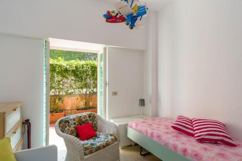 サンタ・マルゲリータ・リグレにあるCasa Vacanze Belvedereのベッド1台、椅子、窓が備わる客室です。
