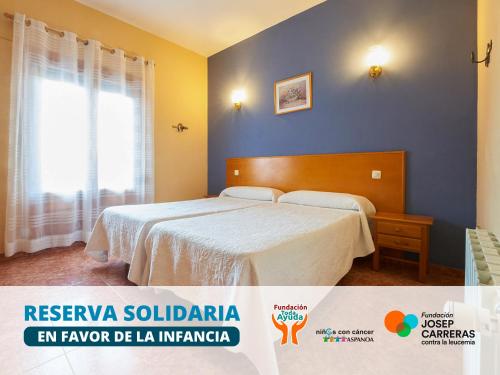 Un dormitorio con una cama y una pared azul. en Hotel La Rueda 3000, en Mora de Rubielos