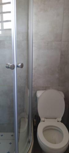 a small bathroom with a toilet and a shower at Gravity Apartments & Lodges in Mazabuka