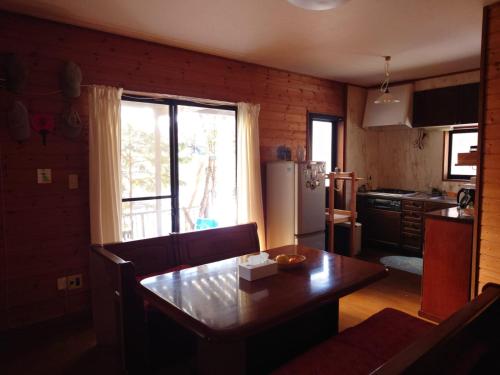 a kitchen with a wooden table and a dining room at 戸隠の自然に佇む 小さな一棟貸しコテージ Private Tiny Cottage in the Nature of Togakushi Breath in Earth in Nagano