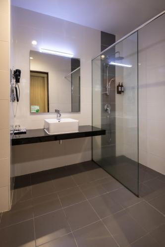 a bathroom with a sink and a glass shower at One Pacific Hotel and Serviced Apartments in George Town