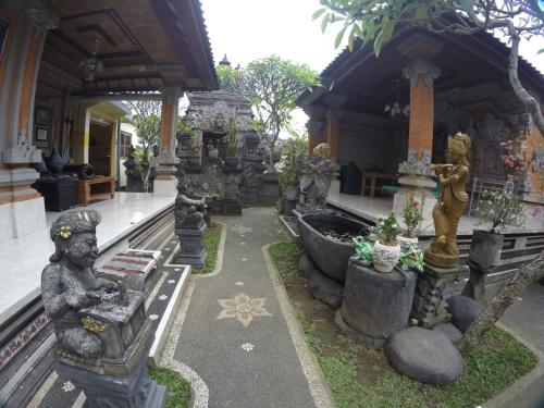 a temple with statues and plants in a courtyard at Eka's Homestay in Ubud