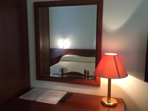 a lamp sitting on a desk next to a mirror at Castelvetere Hotel in Caulonia
