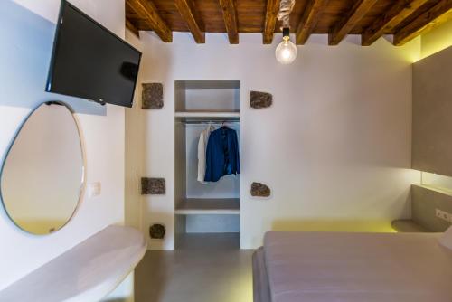 a room with a bed and a tv and a mirror at Plaka Suites in Plaka Milou