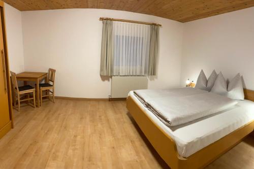 a bedroom with a bed and a table in it at Ferienwohnung Bargehr Marion in Sankt Gallenkirch