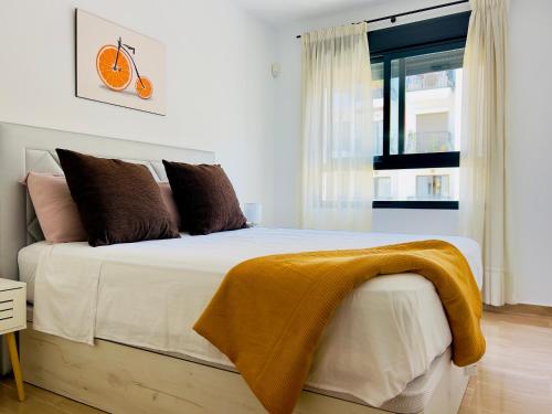 a bedroom with a bed with a yellow blanket on it at Calamora I by Sun & Sea Homes in Moraira
