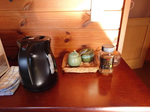 a table with a tea kettle and jars on it at 戸隠の自然に佇む 小さな一棟貸しコテージ Private Tiny Cottage in the Nature of Togakushi Breath in Earth in Nagano