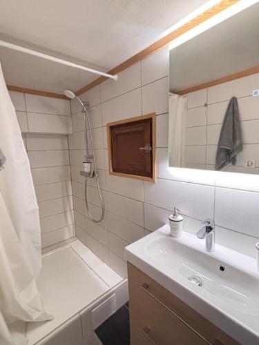 a bathroom with a shower and a sink and a mirror at L'appart du Yeti, cocon rénové avec goût, multipass été, ménage et linges compris in Les Gets