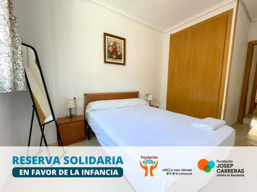 a bedroom with a bed and a wooden door at Apartamentos Caribe Marina D’Or 3000 in Oropesa del Mar