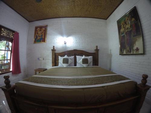 a bedroom with a wooden bed in a room at Eka's Homestay in Ubud