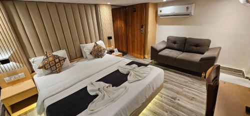 a bedroom with a large bed and a couch at hotel Sunrise Residency in Mumbai