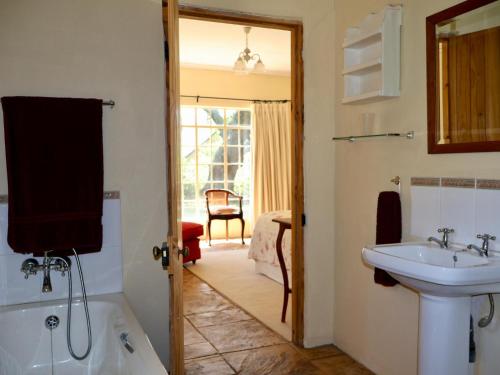 een badkamer met een wastafel, een toilet en een bad bij Winnaarspoort Lodge in Hydro