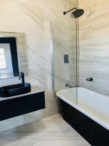 a bathroom with a bath tub and a sink at Khulanathi Guesthouse in Engcobo