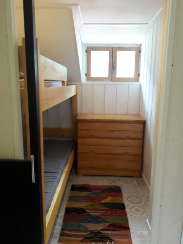 a small room with bunk beds and a window at Le Vieux Logis 2 in La Celle-sous-Gouzon