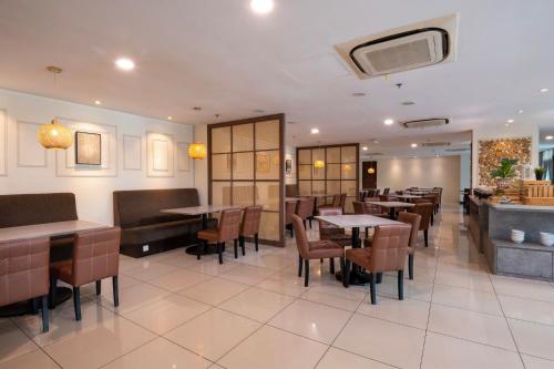 Un restaurante con mesas y sillas y un bar. en One Pacific Hotel and Serviced Apartments, en George Town