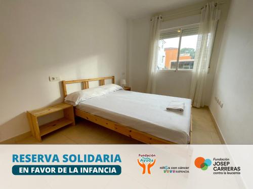 a small bedroom with a bed and a window at Apartamentos Los Almendros 3000 in Oropesa del Mar