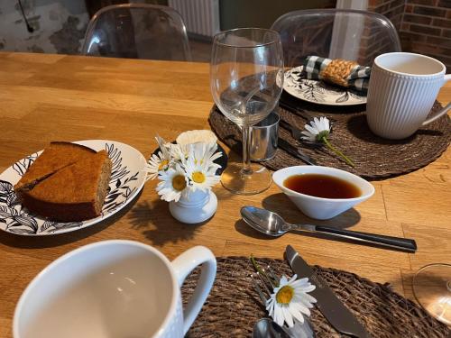 een tafel met borden eten en een kopje thee bij Le Chant Des Roseaux in Nantheuil