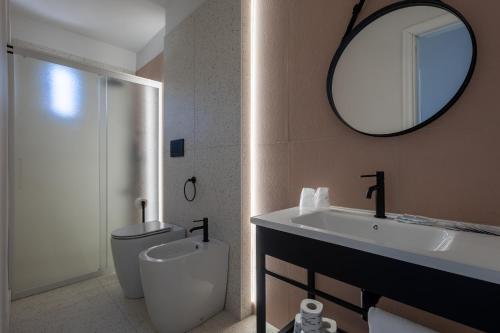 a bathroom with a toilet and a sink and a mirror at Centro Vacanze Poker in Casalbordino