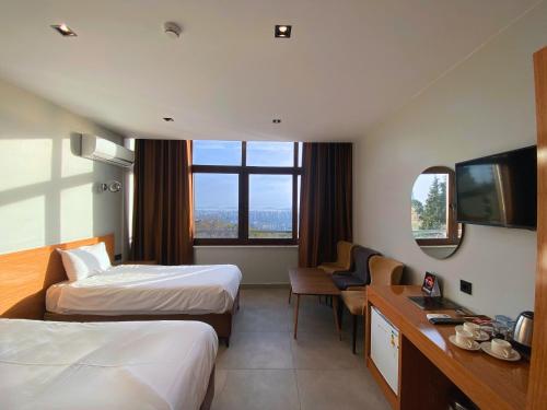 una camera d'albergo con due letti e una televisione di Elite Marmara Bosphorus Çamlıca a Istanbul