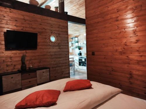 una camera da letto con un letto con cuscini rossi e una TV di Popa Cabana a Sibiu