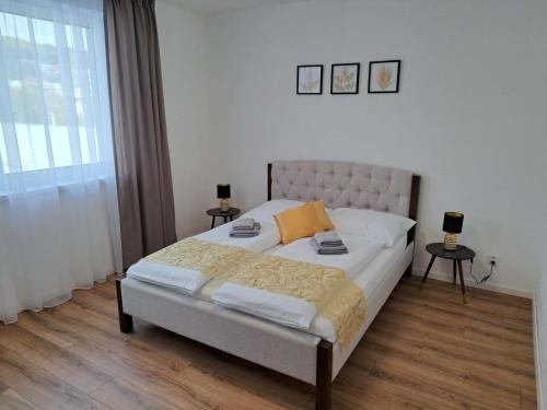 una camera da letto con un letto con due tavoli e una finestra di Apartmány Karpatia s historickým výkladom a Svidník