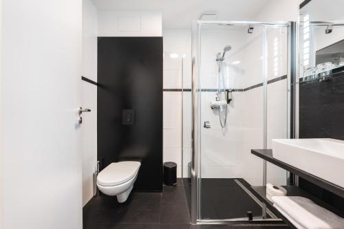 a bathroom with a toilet and a shower and a sink at Maximus Resort in Brno