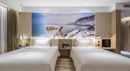 - 2 lits dans une chambre d'hôtel ornée d'une peinture murale dans l'établissement Atour Hotel Weihai Shidao, à Dongshan