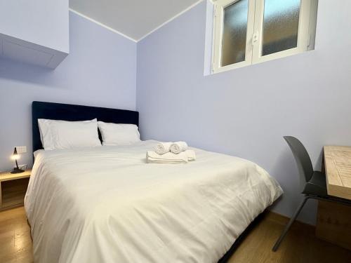 een wit bed met twee handdoeken erop bij Mario's Holiday House in Barcuzzi