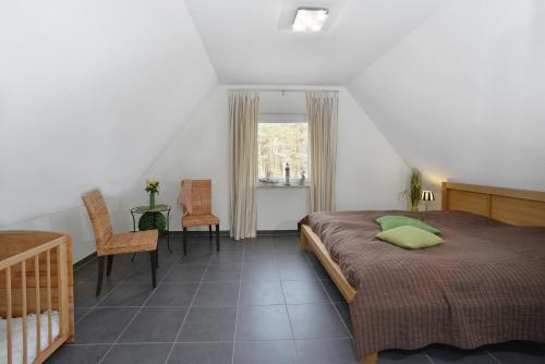 Schlafzimmer mit einem Bett, einem Tisch und Stühlen in der Unterkunft Ferienhaus Boddenblick in Breege