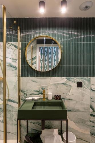 a bathroom with a green sink and a mirror at Sol Hotel - Saint Mandé in Saint-Mandé