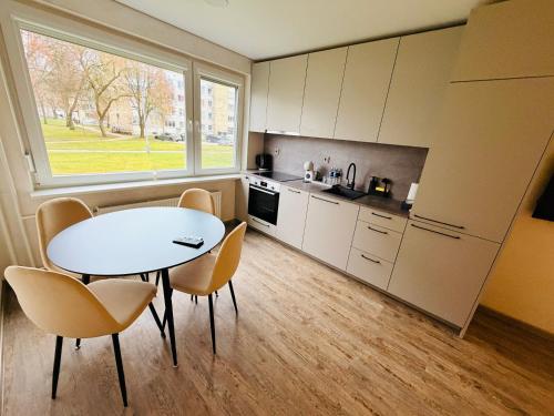 een keuken met een tafel en stoelen in een kamer bij Ūla Apartments in Mažeikiai