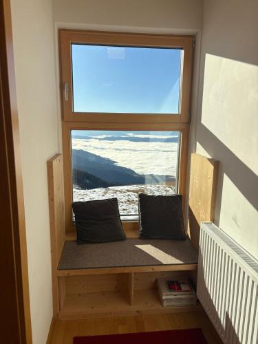 einem Fensterplatz mit zwei Kissen davor in der Unterkunft Koralpenhaus Schutzhaus in Goding